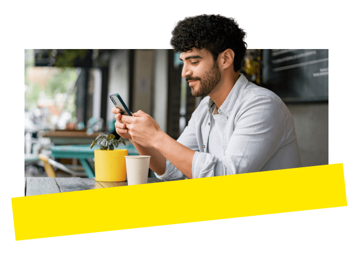 Profi nutzt die prämierte Telefonanlage von GoTo auf dem Mobilgerät und arbeitet in einem Café im Freien.
